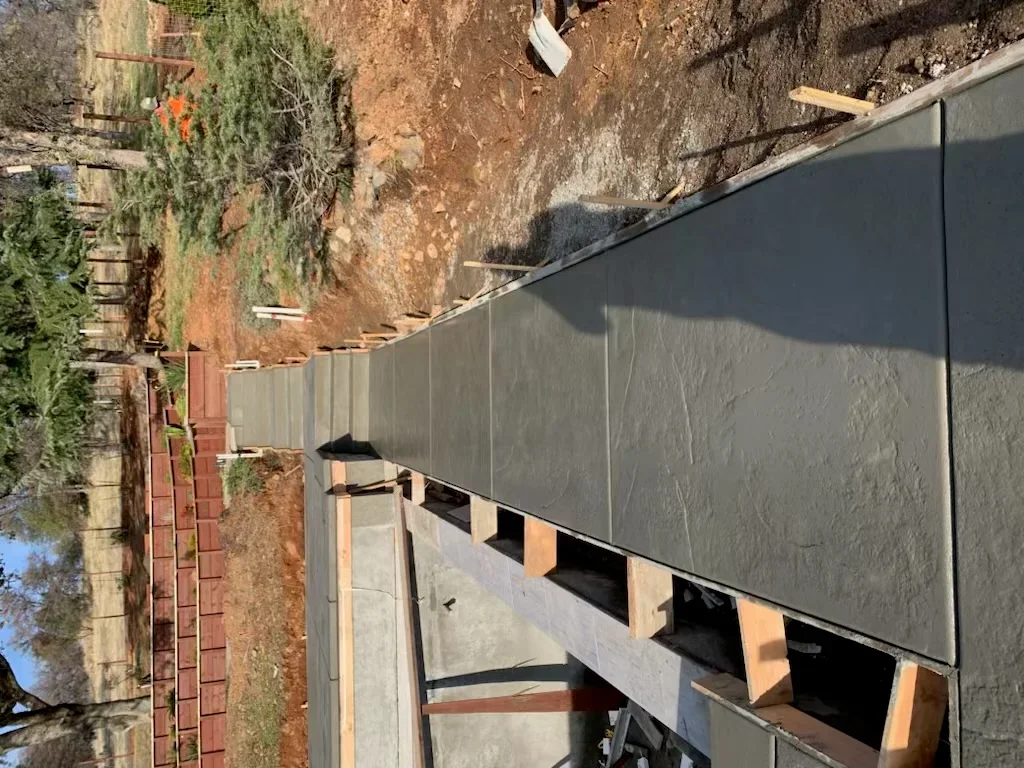 Gray concrete foundation wall with wooden block supports and brick veneer detail