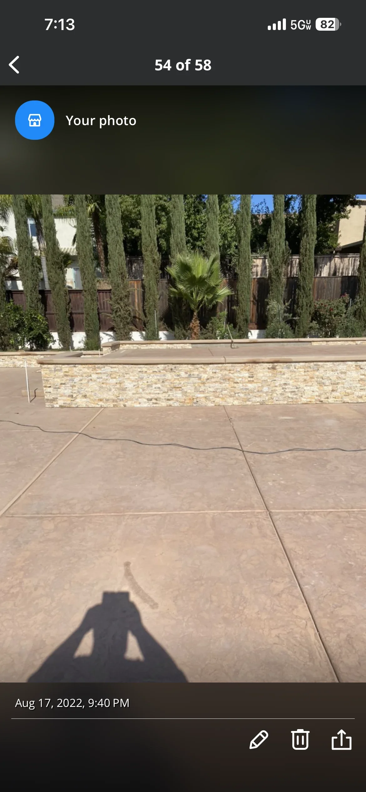 Newly poured concrete driveway with control joints and stone retaining wall