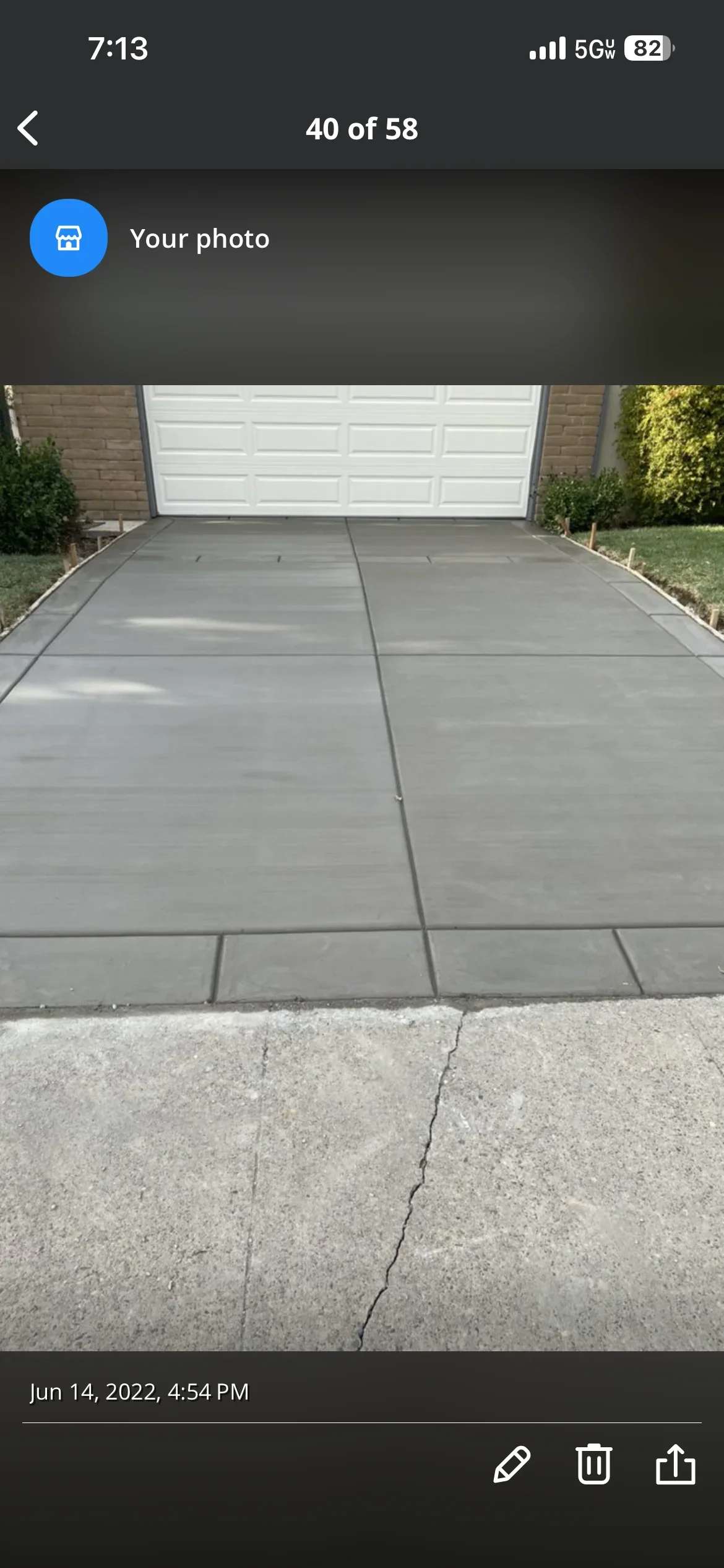New gray concrete driveway with control joints and white garage door in background