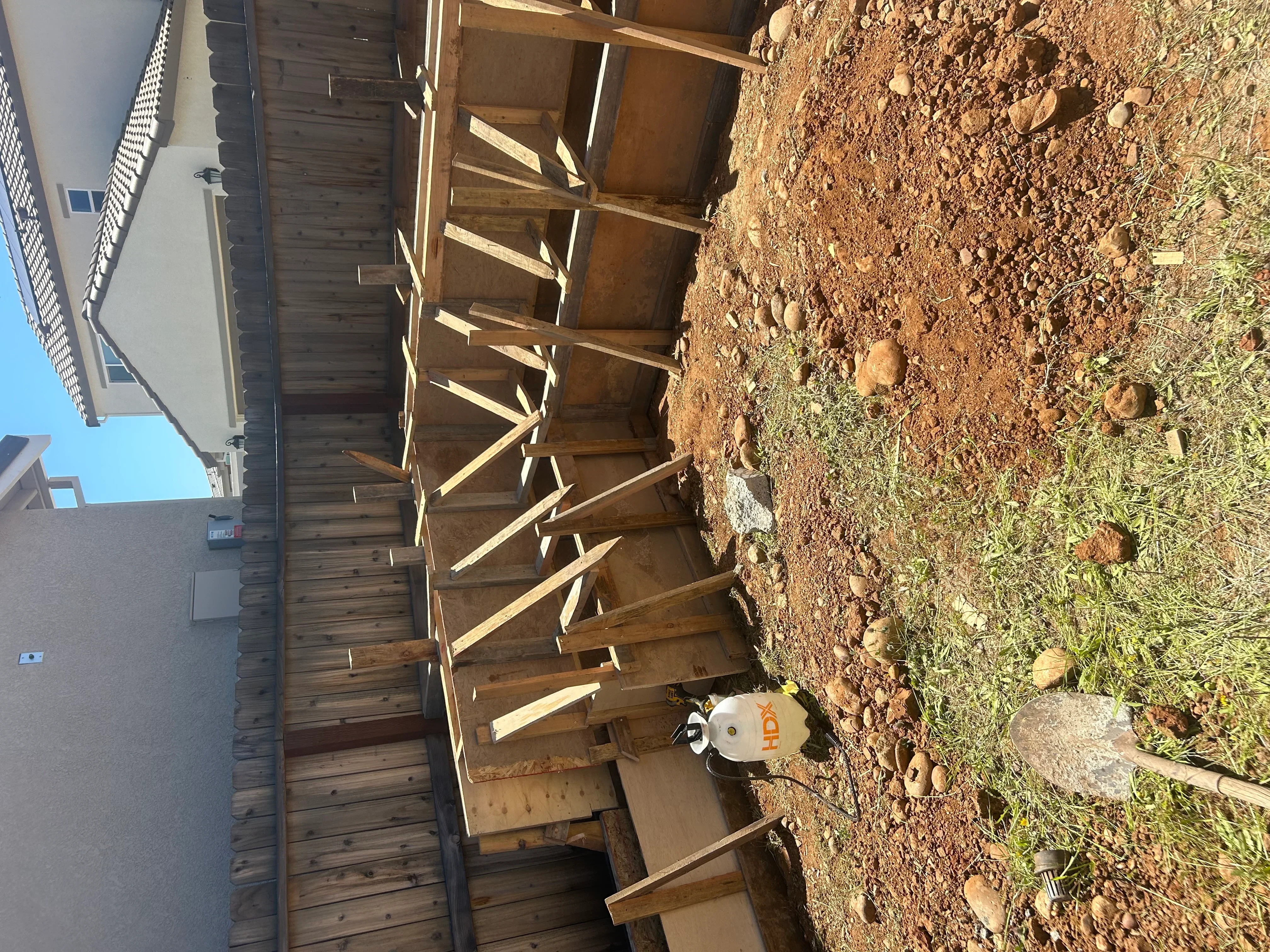 Excavated residential lot with wooden bracing and prepared soil foundation base
