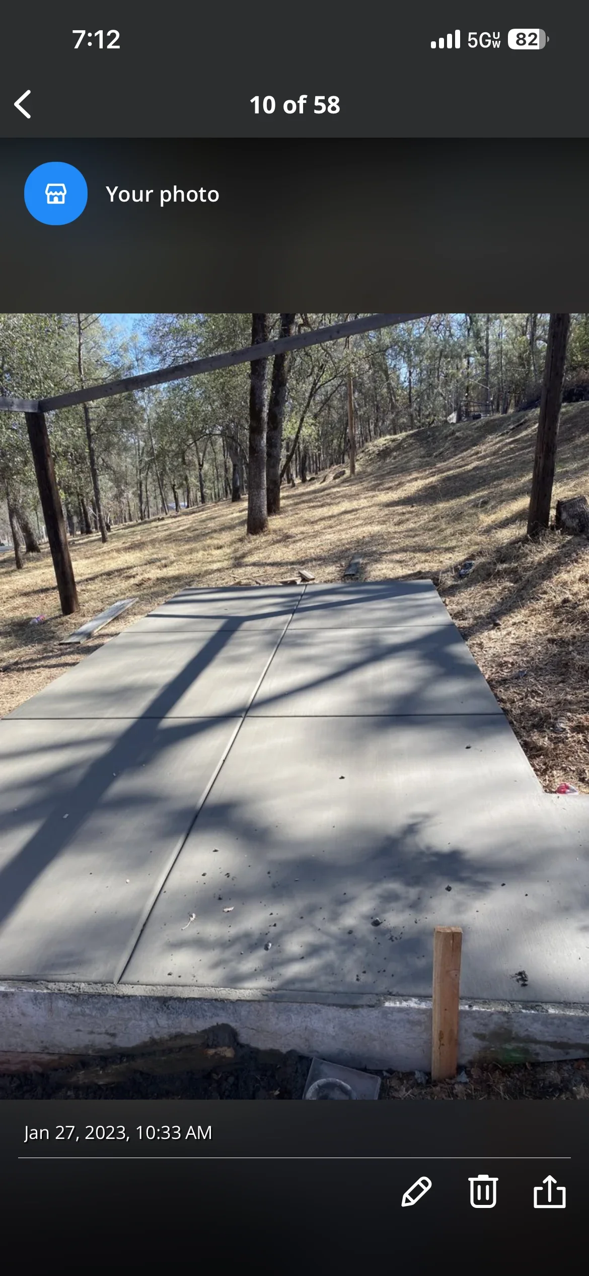 Finished concrete pad with steel pergola frame on wooded hillside