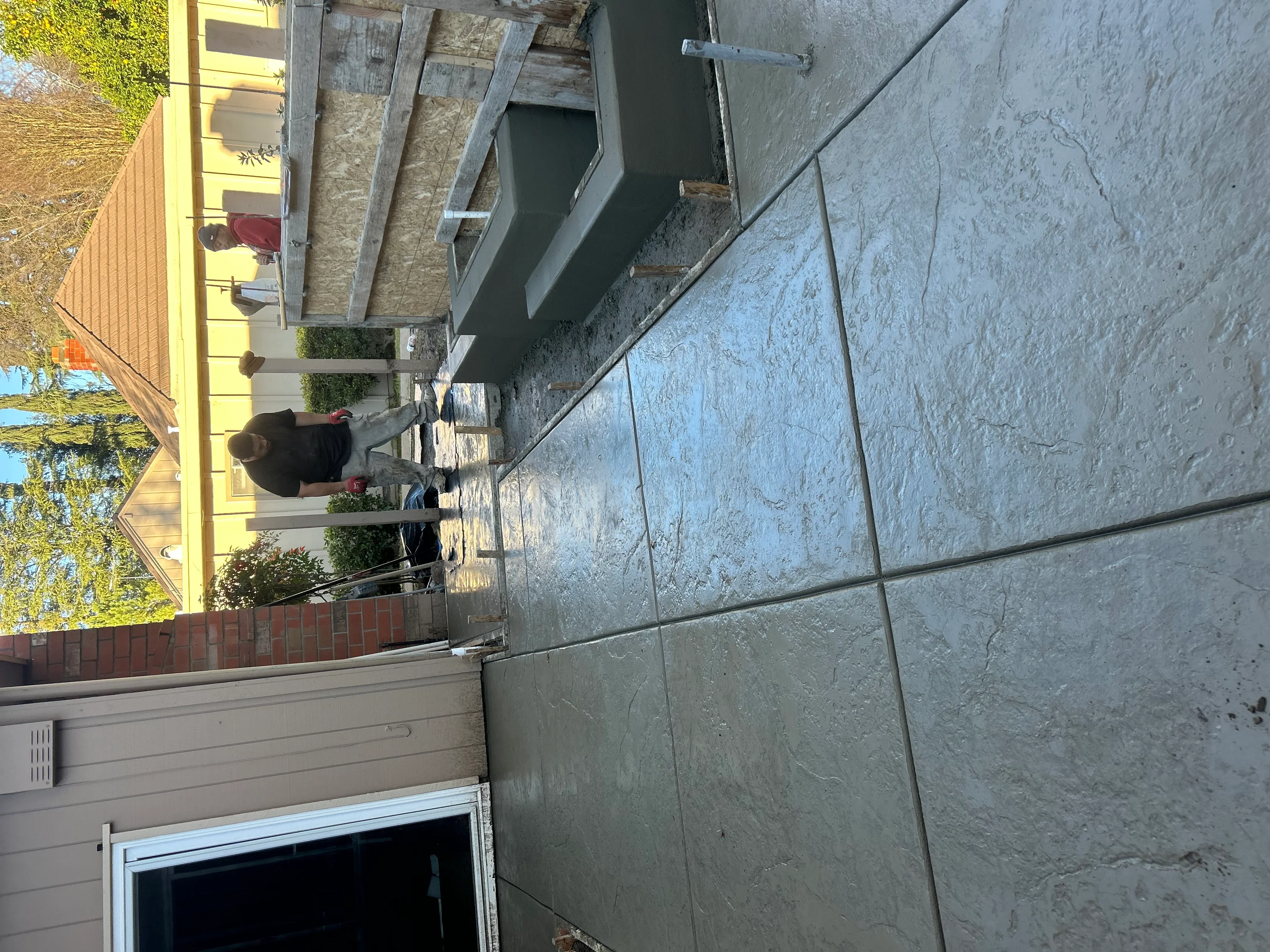 Finished concrete driveway with control joints and gray finish on residential property