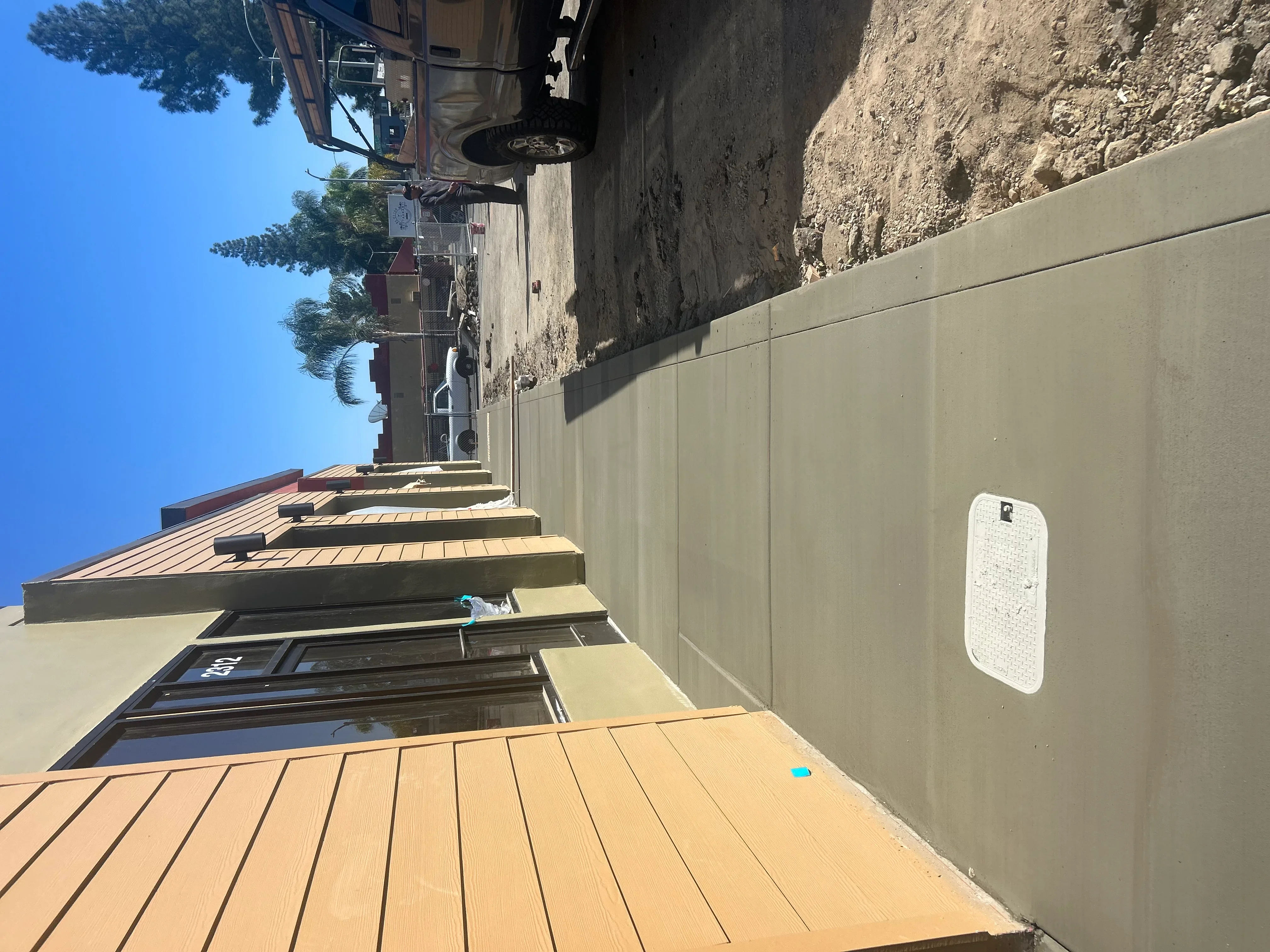 Finished concrete patio with retaining wall and metal roof overhang in Sacramento