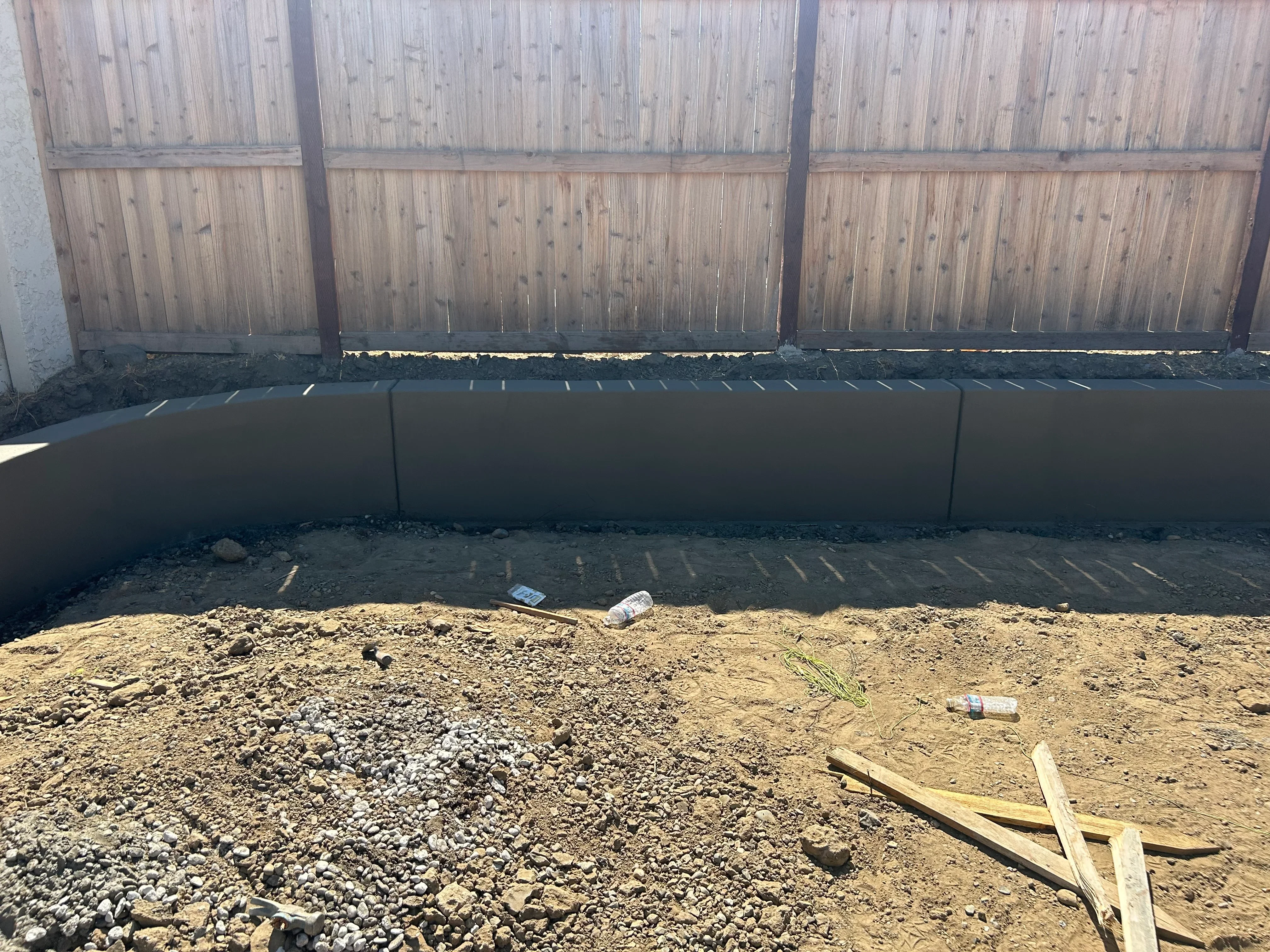 Concrete retaining wall with geotextile backing and gravel base during construction