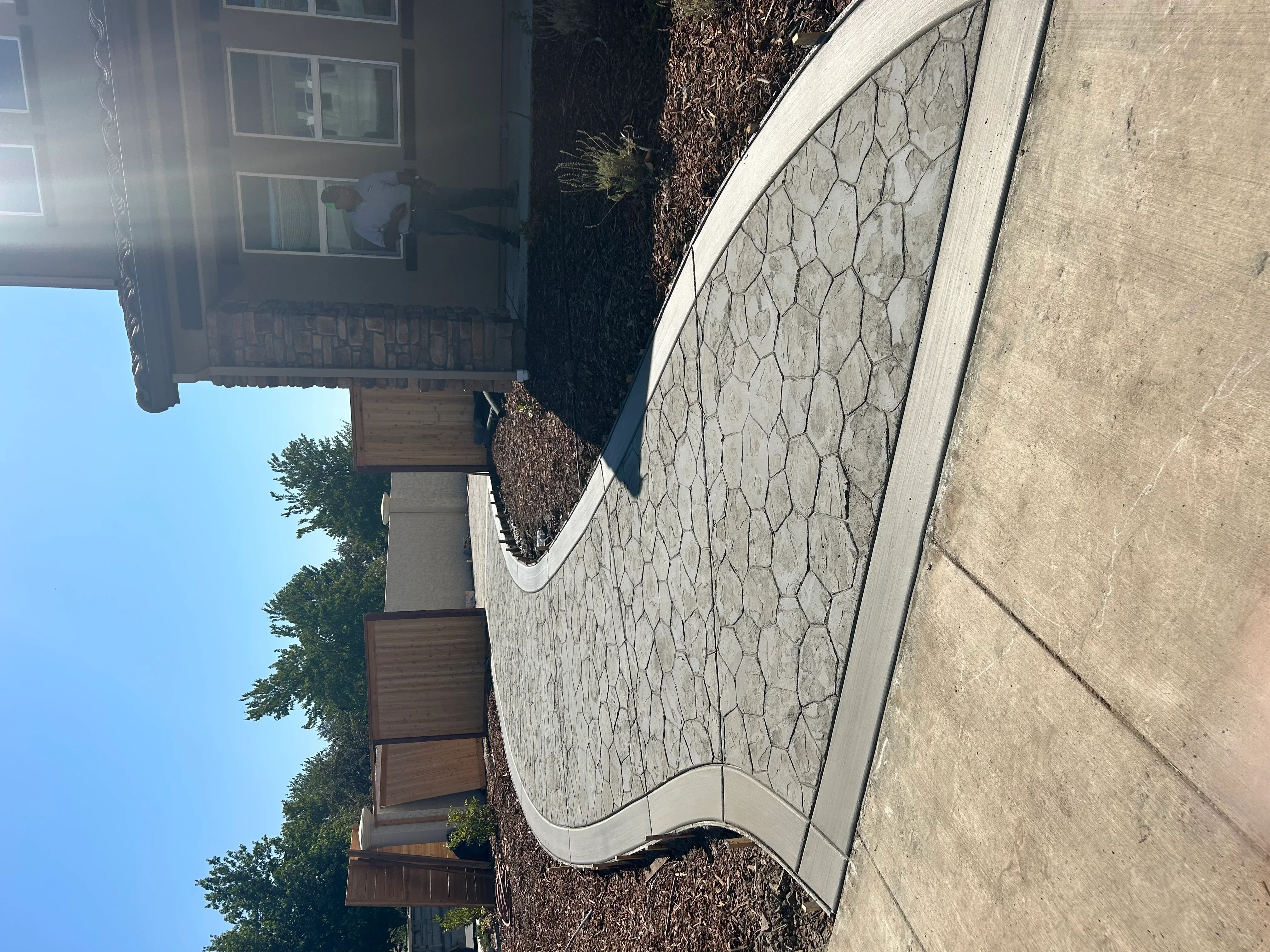 Decorative stamped concrete patio with stone pattern design and curved borders