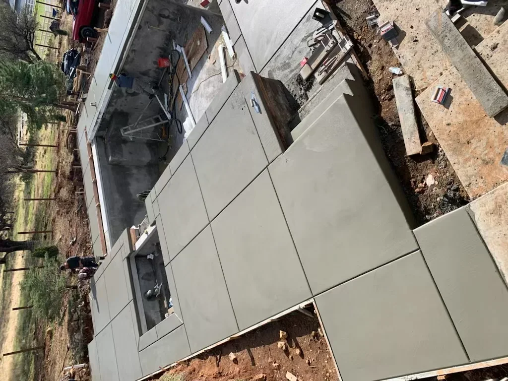 Newly poured concrete foundation pads and walls for residential construction project