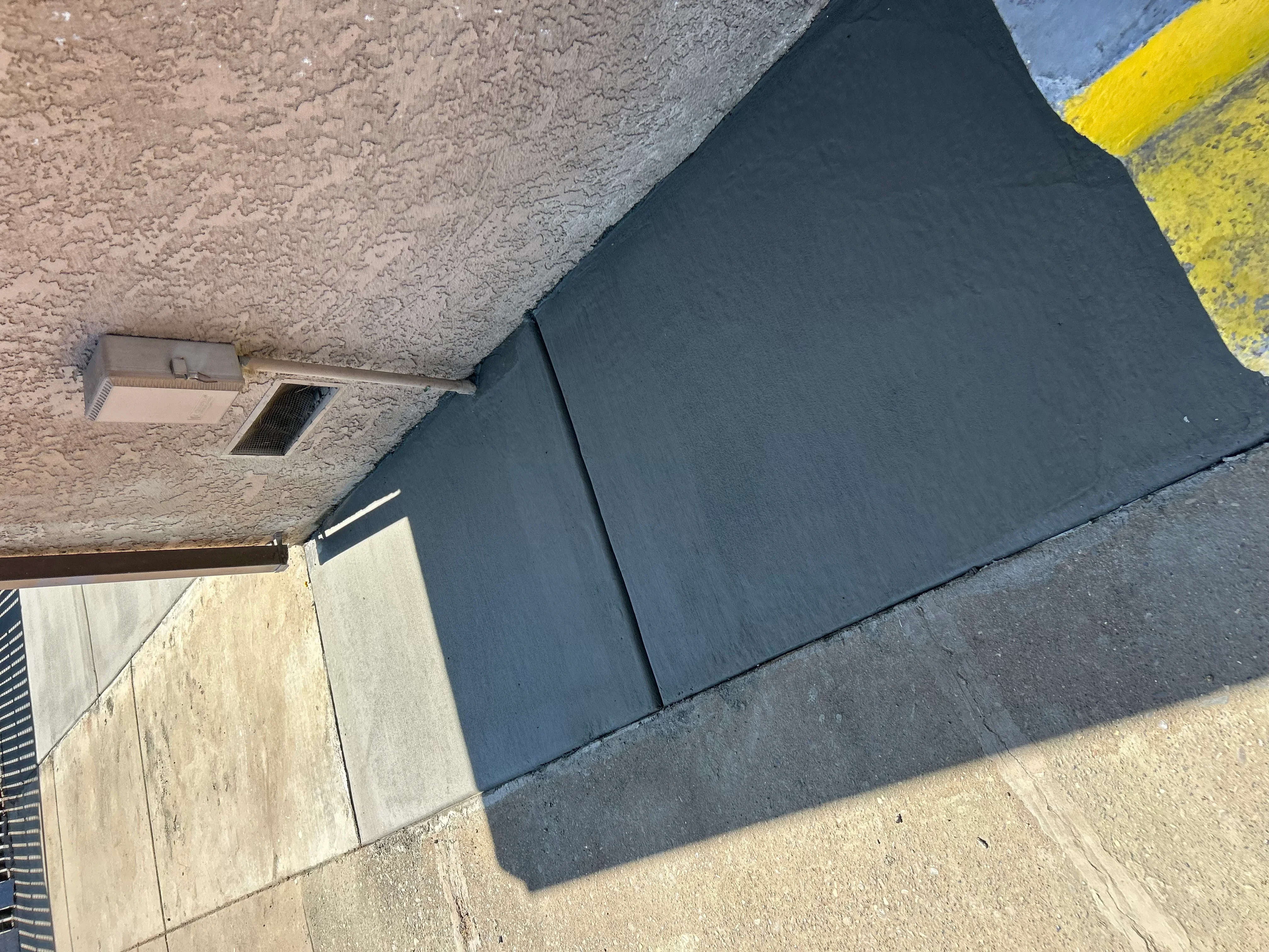 Newly installed dark concrete driveway with clean edges and proper grading