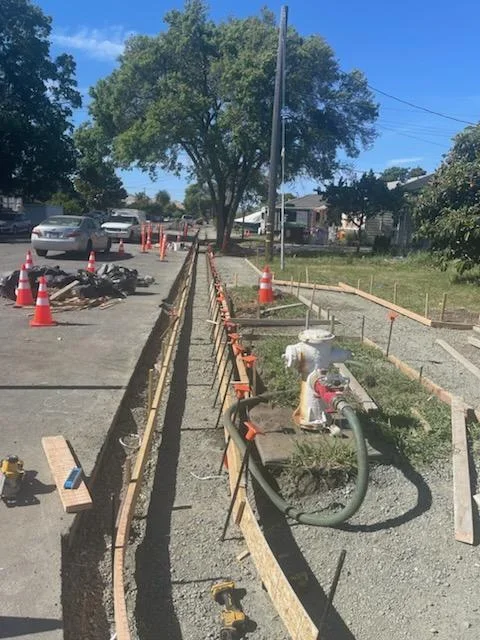 Residential concrete foundation work with wooden forms and safety barriers