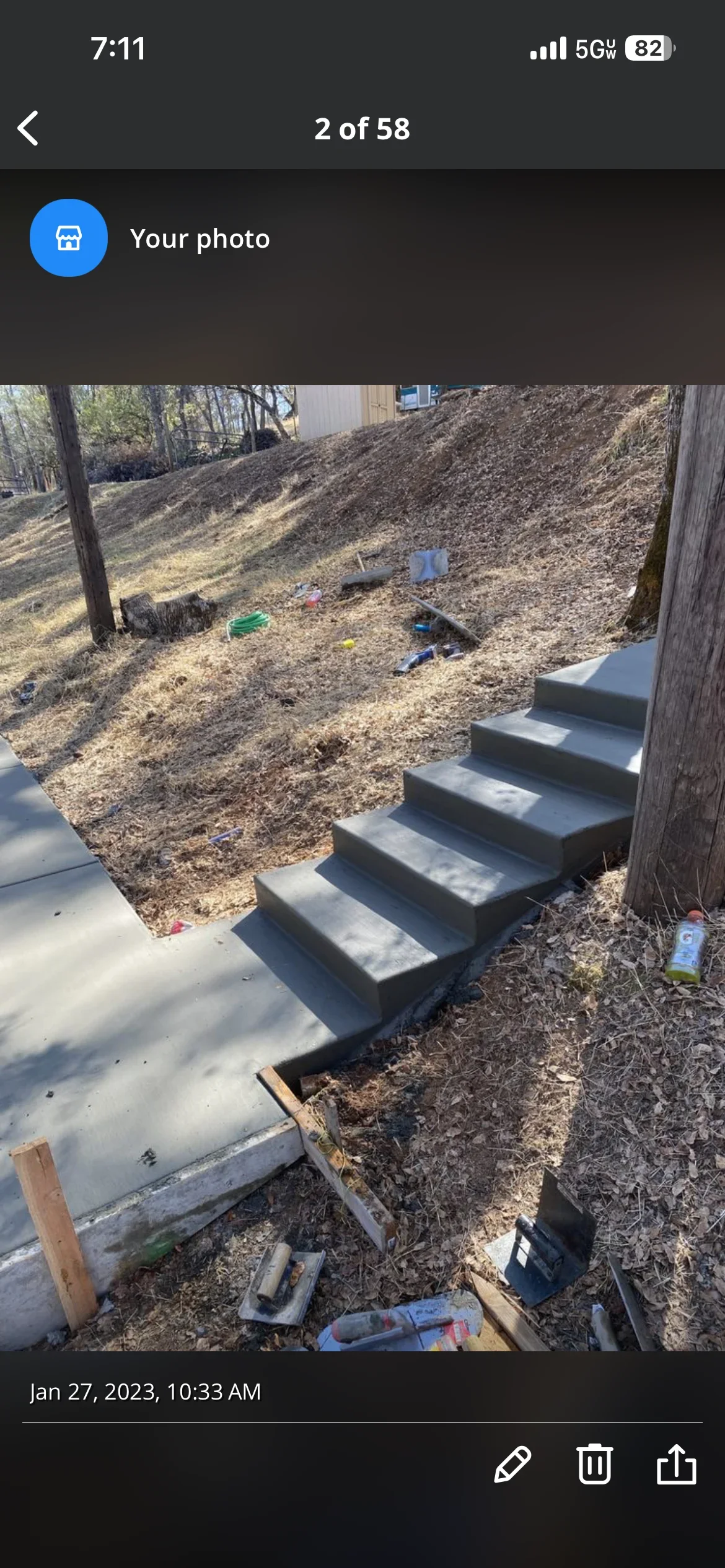 Five concrete steps installed on sloped yard with mulch landscaping and wooden fence